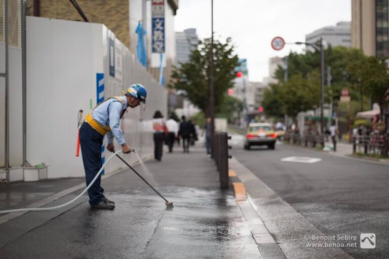 Homem limpando uma calçada