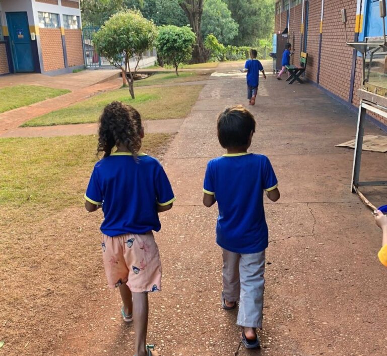 Alunos indígenas caminhando em escola.