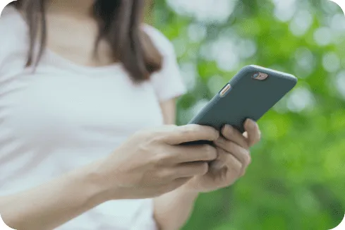 Uma pessoa usando um smartphone, foco nas mãos e no dispositivo.